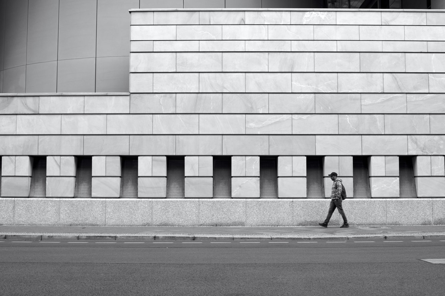 Person läuft vor moderner Architektur der britischen Botschaft in Berlin Mitte